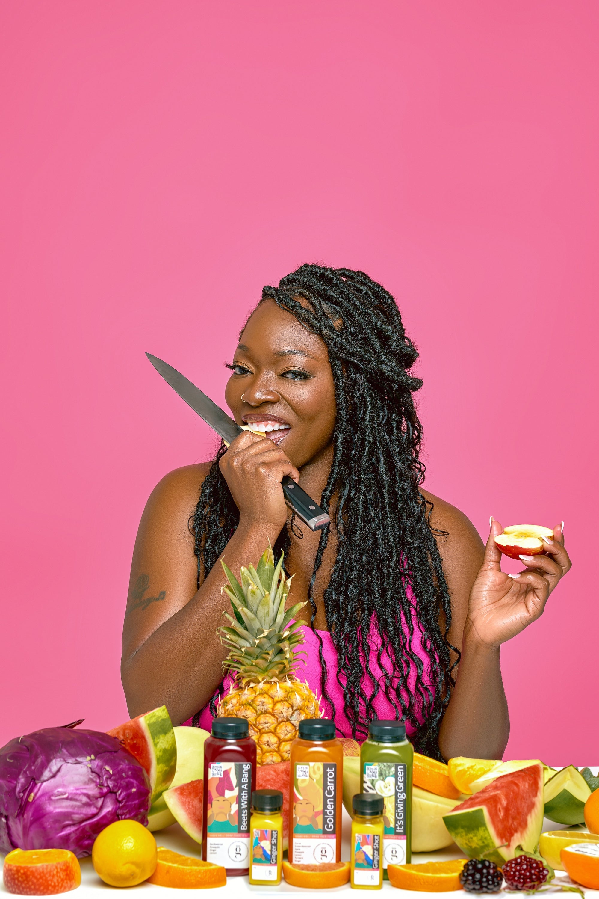 Black woman cutting fruit holding a knife